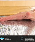 Hand pressing on adhesive layer of 20 Pack Peel And Stick 3D Foam Brick Wall Panels For Interior Decor Self Adhesive Black Wall Tiles Covering 115 Square Feet Easy DIY Install Acoustic Boost Safe And Environmentally Friendly, showing strong adhesive application.