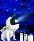 A white galaxy projector star night light designed like an astronaut, casting nebula and galaxy effects in a blue-lit room for epic nights.