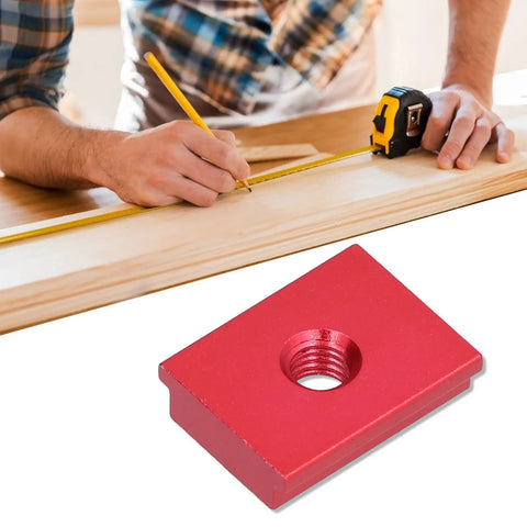 Red Aluminum Alloy Sliding Nut For T Track Systems with Dual Metric Threads next to woodworking setup