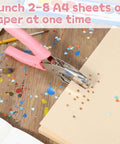 Pink Star Shaped Hole Puncher Five Millimeter With Rubber Grip Handle, used on a paper stack, crafting table background.
