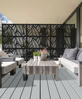 2x4 Black Outdoor Decorative Screen Panels with leaf pattern, polypropylene, weather-resistant, on a patio with furniture.