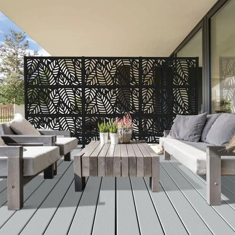 2x4 Black Outdoor Decorative Screen Panels with leaf pattern, polypropylene, weather-resistant, on a patio with furniture.