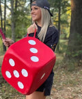 Person holding the High Roller Foam Archery Target Cube With 21 Bullseyes, 13 Inch By 13 Inch, in a forest, showing portability