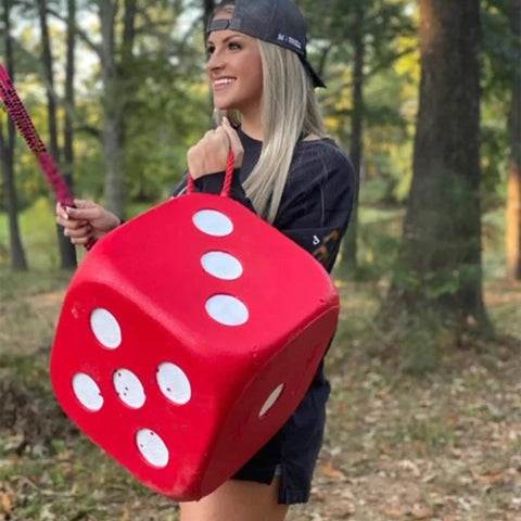 Person holding the High Roller Foam Archery Target Cube With 21 Bullseyes, 13 Inch By 13 Inch, in a forest, showing portability