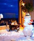 Outdoor scene with No Mess Smokeless Round Propane Fire Pit For Outdoors With Durable Weather Resistant Cover, 24-Inch Diameter, 58,000 BTU, beside snowman.
