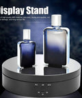 Spiffy Omquot Electric Rotating Jewelry Stand With 360 Degree Swivel Plate And Usb Charging Port For Watches Cosmetics And Toys In Sleek Black Finish showcasing two perfume bottles on a mirror-like surface.