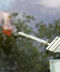 Long Handle Adhesive And Vinyl Decal Remover With Razor Blade Scraper used on glass to peel off sticker efficiently.