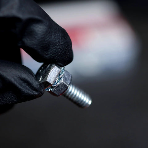 Person holding steel bolt against blurred background, not related to Large Cotter Pin Key 144 Pc Assortment Set 1 Eighth By 2 In To 1 Quarter By 3 In