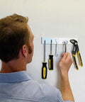 Man hanging tools on wall using Magnetic Paint And Primer Water Based High Yield 32oz 4 Pack Grey Turn Any Surface Into A Magnet Wall