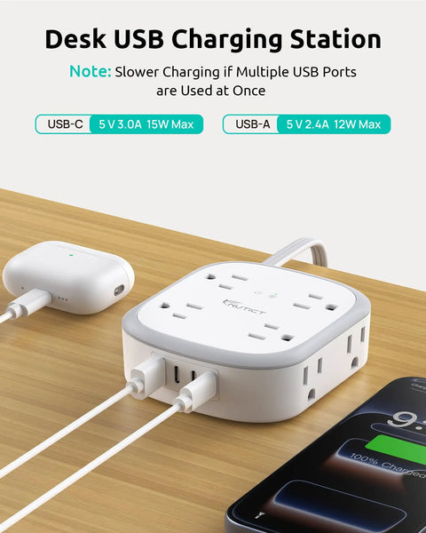360 Degree Rotating Flat Plug Surge Protector Power Strip With 1 Foot Extension Cord For Tight Behind Furniture Spaces And Heavy Nightstands with USB ports and charging cables on wooden desk.