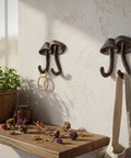 Straight Up Legit Mushroom Wall Hooks Set Of Two Heavy Duty Cast Iron Coat Hangers With Antique Black Finish mounted on wall with keys and bag.