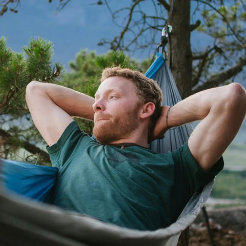 Person relaxing in a Neolite Single Camping Hammock Ultra Lightweight Portable Nylon Parachute Hammock For Backpacking in nature