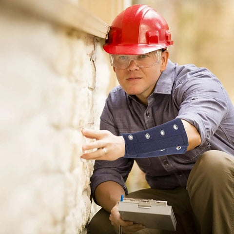 Man wearing Heavy Duty Cut Resistant Wrist Sleeves Built Tough With Reinforced Denim For Industrial Steel Handling Abrasion Proof Forearm Guards That Kick Ass At Work Sites (1 Pair) while inspecting a wall.