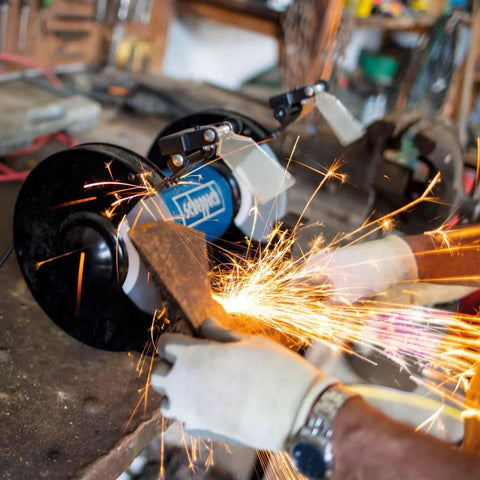Heavy Duty Double Sander Benchtop Grinder With 500 Watt Motor in use, showing sparks while grinding metal on a workbench.