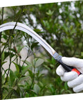 Portable Reaping Hook For Weeding And Harvesting Lightweight Durable Gardening Tool With Sharp Edge in use on a bush.