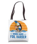 Work Hard Foil Harder Wing Foil Wingsurfing Tote Bag with graphic of windsurfer on water, black handles, 16x16 in size