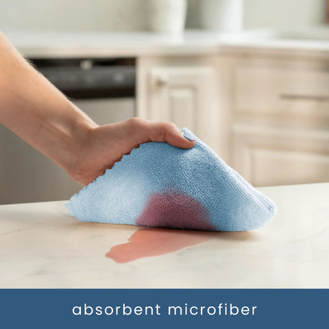 Blue microfiber cleaning cloth held in a hand on a kitchen counter.