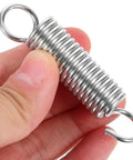 Close-up of stainless steel small tension spring with hook, part of 10 Pack Extension Springs Set Stainless Steel Small Tension Springs For Return And Pull Mechanisms Heavy Duty Coil Kit For Doors Lids Screens And Garage Projects.
