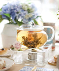 Kyoto 2-In-1 Tea Kettle And Tea Maker Glass Teapot With Removable Loose-Leaf Infuser on a decorative table with flowers and pastries