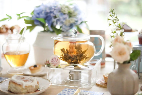 Kyoto 2-In-1 Tea Kettle And Tea Maker Glass Teapot With Removable Loose-Leaf Infuser on a decorative table with flowers and pastries