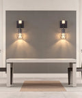 BANGANMA 2 Pack Farmhouse Wall Sconces, Hardwired E26 Wood Cage for Bedroom, set above a modern table with chairs.