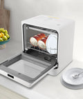 Countertop Dishwasher With Top Shelf Cleaning And Zero Hassle Install This Mini Portable Machine showing stacked bowls and plates inside.