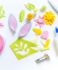 Precision craft knife with replaceable blade and metal handle among colorful felt shapes and glue bottle