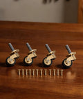 Solid Brass Caster Wheels 4pcs Silent Bearing Furniture set on a wooden surface with screws for installation.
