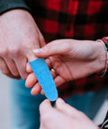 Person applying a blue nitrile antistatic finger sleeve for protection during electronics assembly tasks.