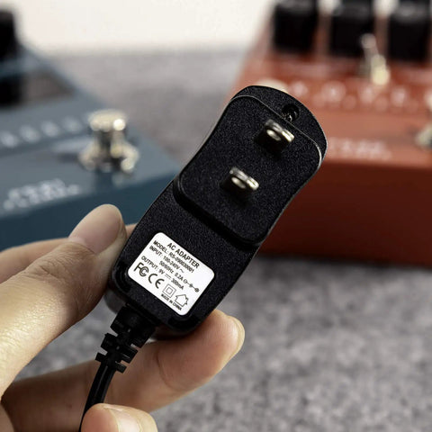 9V 300mA Power Supply For Electric Guitar Effects Pedals With Tip Negative 5.5mm X 2.1mm Barrel Connector in hand