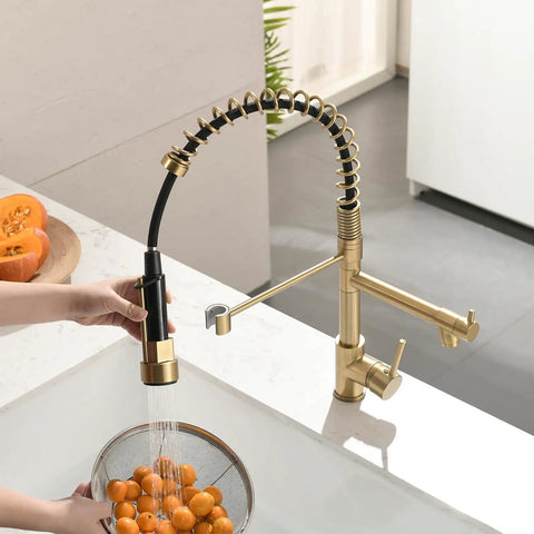 AIMADI Brushed Gold Kitchen Faucet with Pull Down Sprayer in action, washing fruits in a colander over a sink.
