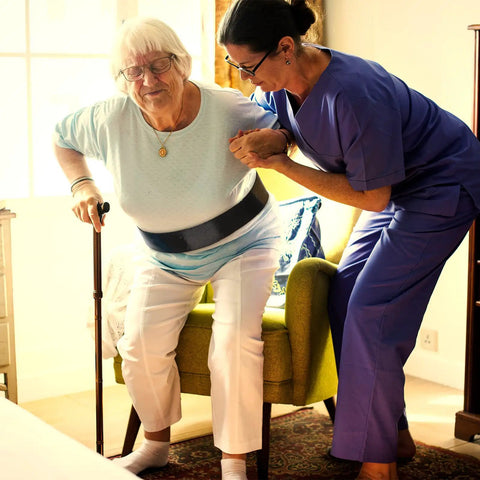 Caregiver assisting elderly woman with Vinyl Gait Belt Transfer for 60 Inch Assistance Devices with Metal Buckle.
