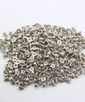 Rock Solid M3x5mm Flat Head Phillips Screws 100 Pack For 2.5 Inch SSD And Hard Drives nickel plated steel fasteners scattered.