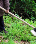 Heavy Duty Garden Hoe Tool With Solid Manganese Steel Blade For Weeding, Soil Loosening, And Planting In Backyard And Farm in use.
