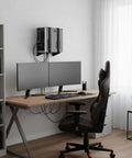 Universal PC Wall Mount Rock Solid Metal Support Bracket For Desktop Towers And CPUs above dual monitors on wooden desk.