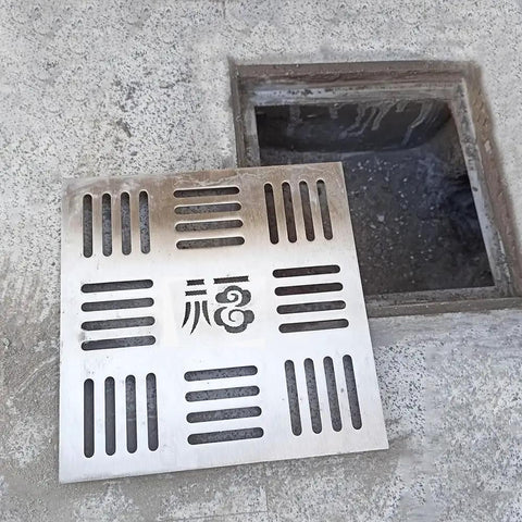 Smooth Operator 304 Stainless Steel Square Shower Drain Cover And Yard Catch Basin Grate placed over a trench in outdoor pathway.