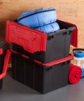Haul Heavy Loads With Ease Using These Tough As Nails 12 Gallon Storage Totes With Secure Lids For Garage Organization Stackable Heavy Duty Crates Featuring Tie Down Grommets In A Rock Solid 12 Pack Bundle, featuring stacked black bins with red lids and filled with blue bedding.