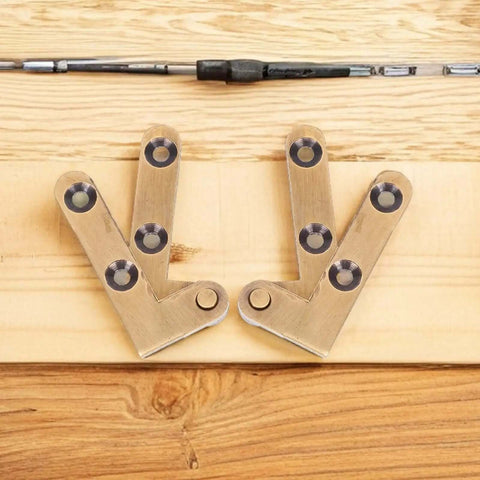 Set of heavy duty bronze pivot door hinges on a wooden surface, featuring hidden self closing hardware for interior doors and cabinets.