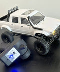 1/16 scale 4x4 RC Rock Crawler Truck with beefed up chassis, twin cab hard body, and remote control on display