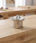 Metal tenon center marker on wooden surface, part of 16 piece dowel and tenon center transfer plugs for woodworking drill alignment tool.