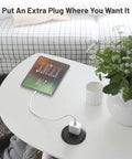 2 Inch Flush Mount Desk Power Grommet With Built In US Outlet And 3.28 Ft Heavy Duty Cord, installed on a white table with tablet.