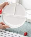 Hands holding a ten inch ceramic divided plate set of four with three compartments for balanced meals portion control, white color.