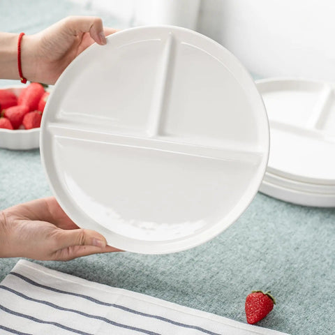 Hands holding a ten inch ceramic divided plate set of four with three compartments for balanced meals portion control, white color.