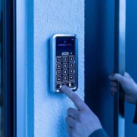 No Drama Smooth Wireless Bluetooth Keypad With Sleek Touch Display For Straight Up Secure Code Entry And Easy Wall Mount Setup In Crisp White Finish For Your Secure Hangout Spot being used to enter a code on a textured wall.