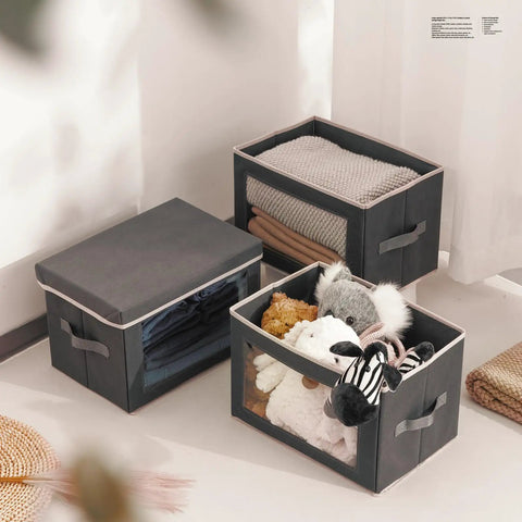 Dark Grey 3 Pack Fabric Storage Bins With Lid And Peek Window Collapsible Closet Organizers Tough Handle crates filled with toys and blankets.
