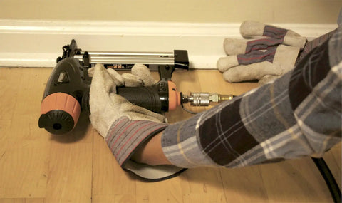 Person using Pro Grade Pneumatic 20 Gauge L Cleat Flooring Nailer for tongue and groove hardwood installs on floor