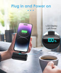 Nifty 5000mAh PD Fast Charging Power Bank For iPhone 14 And 13 Series connected to phone showing 100% charge on LCD display.
