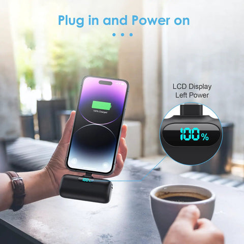 Nifty 5000mAh PD Fast Charging Power Bank For iPhone 14 And 13 Series connected to phone showing 100% charge on LCD display.