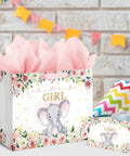13 Inch Large Baby Shower Gift Bag For Girls With Pink Floral Elephant Design And Durable Handles Includes Tissue Paper Pack And Greeting Card No Fuss Quick Gift Wrapping For Baby Showers Or Birthday Parties displayed with pink tissue paper and greeting card on a decorated table.