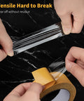 Hands pulling Ultra Thin Clear Double Sided Tape 1.18 Inch By 66 Feet Versatile Mounting Tape against black background.
